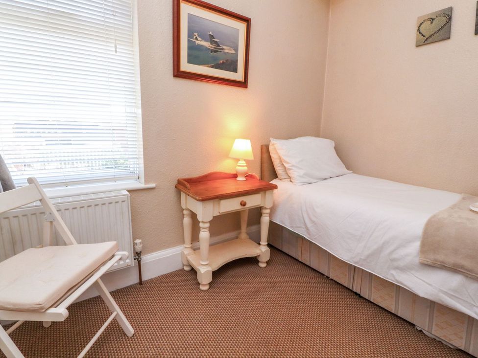 A bedroom with a bed, table, and chair at Lytham House in Lytham St. Annes