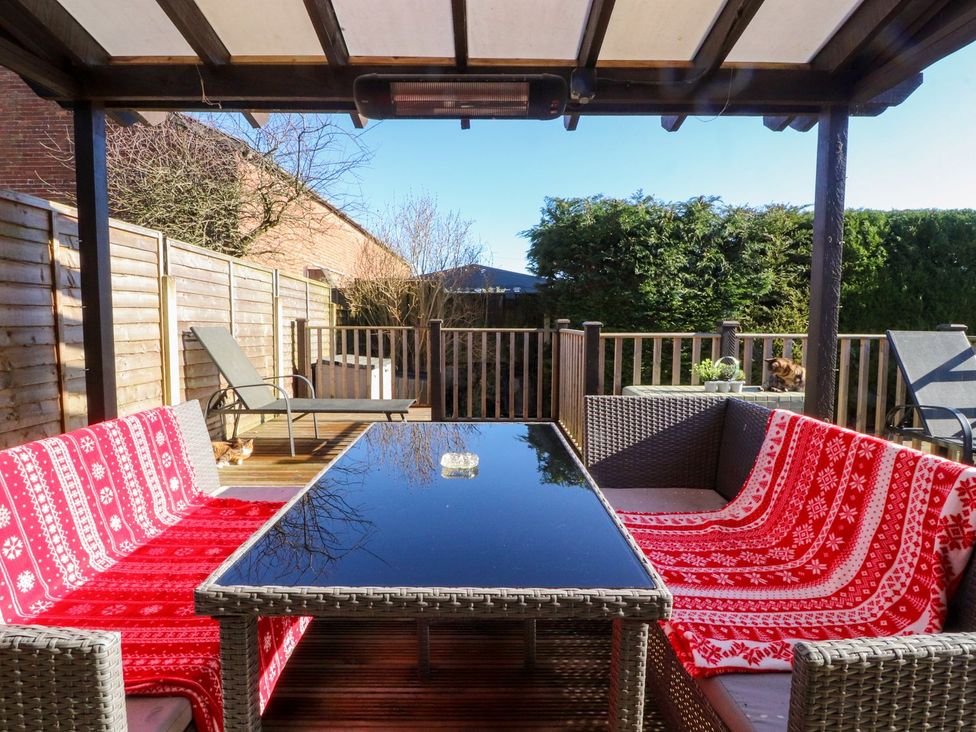 An outdoor seating area with a table and sofa at Lytham House in Lytham St. Annes