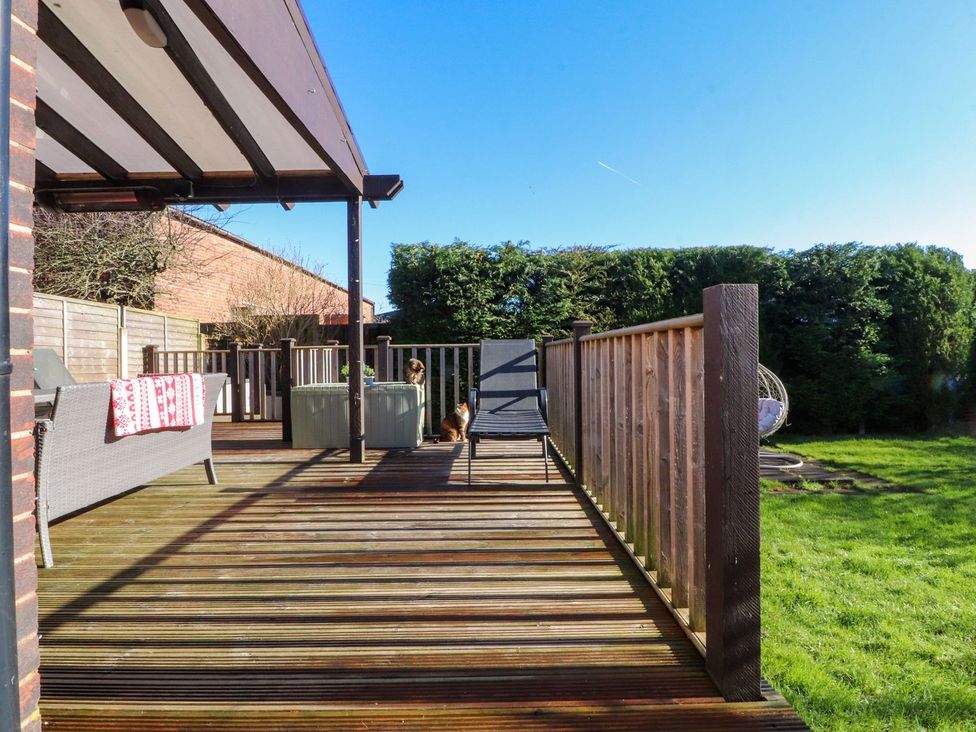 An outdoor deck area with seating and a dog at Lytham House in Lytham St. Annes
