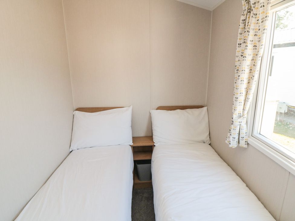 A bedroom with two beds and a window at 14 Pines in Cayton Bay