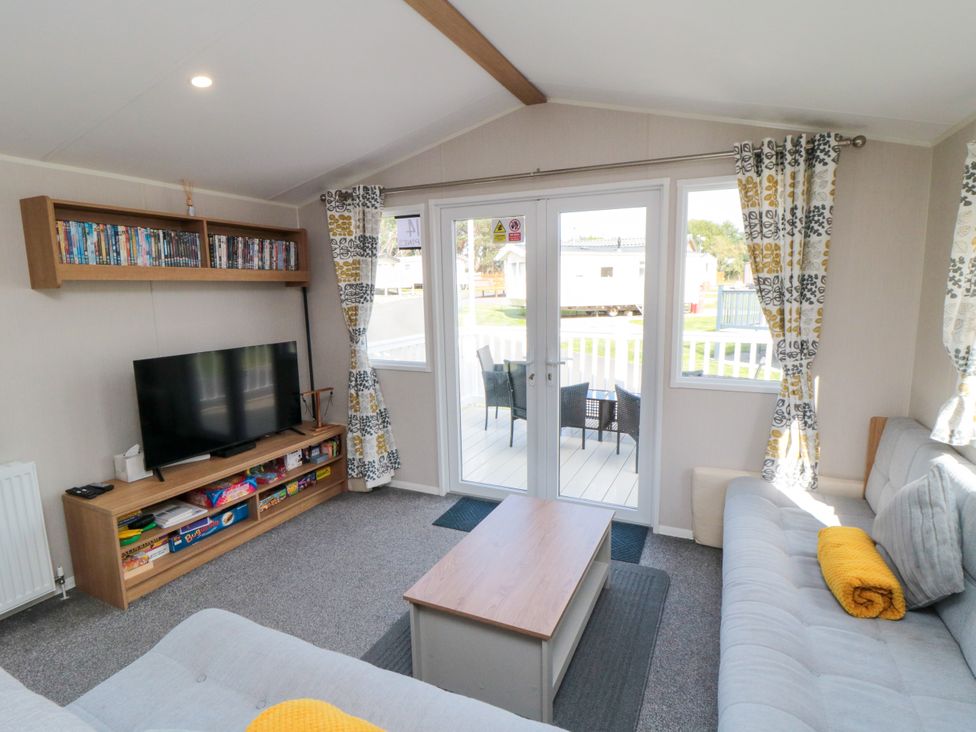 A living room with a television and a coffee table at 14 Pines in Cayton Bay