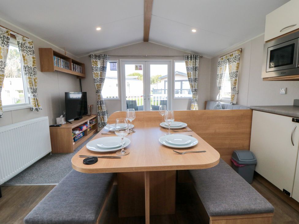 A dining area with table and chairs at 14 Pines in Cayton Bay