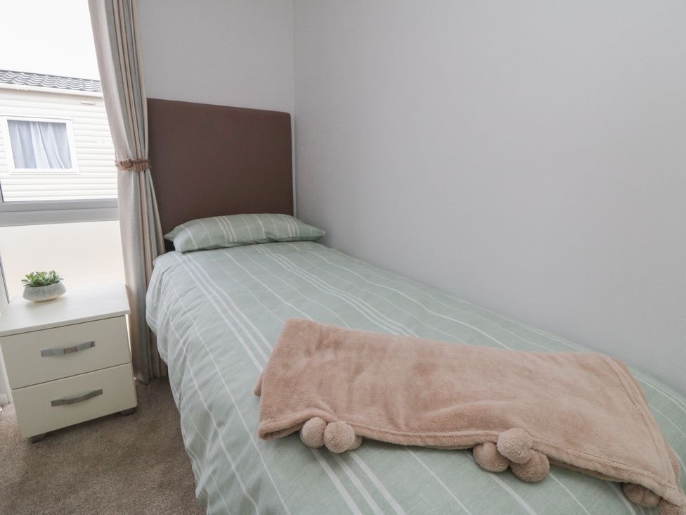 A bedroom with a single bed and a nightstand at Sea Glass Lodge, Saltburn-by-the-Sea