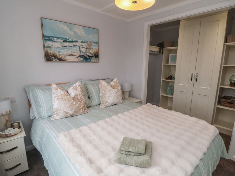 A bedroom with a bed and shelves at Sea Glass Lodge in Saltburn-by-the-Sea