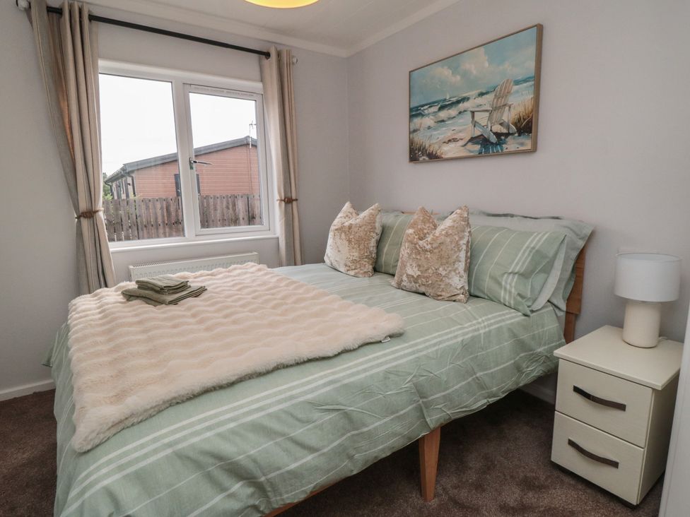A bedroom with a bed and nightstand at Sea Glass Lodge in Saltburn-by-the-Sea