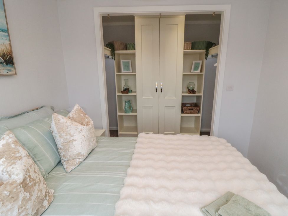 A bedroom with a bed and closet in Sea Glass Lodge Saltburn-by-the-Sea