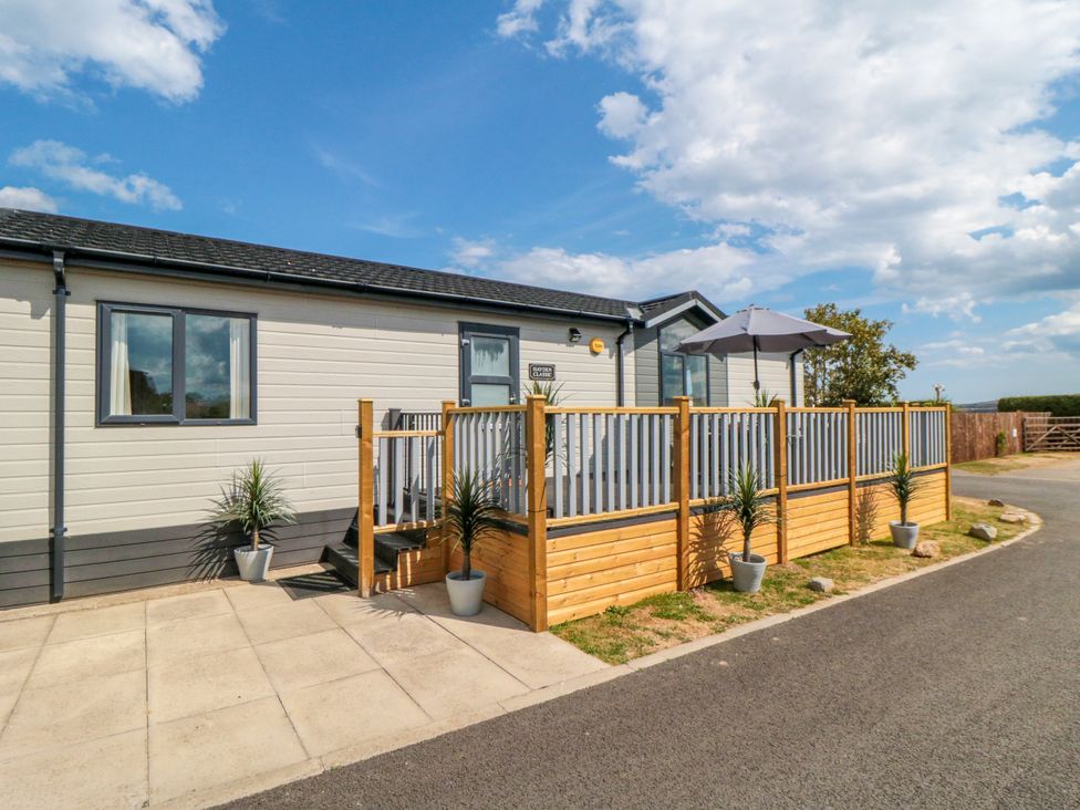 A mobile home with a deck and steps at Sea Glass Lodge in Runswick Bay