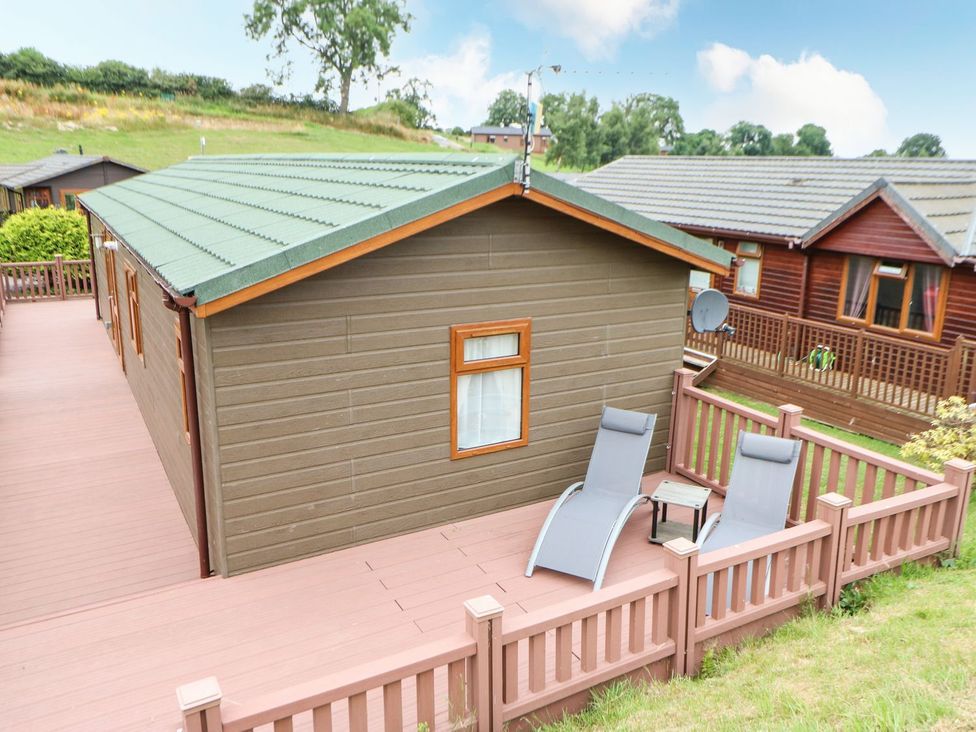 A cabin with a deck and lounge chairs at 10 Poppy Lodge in Richmond