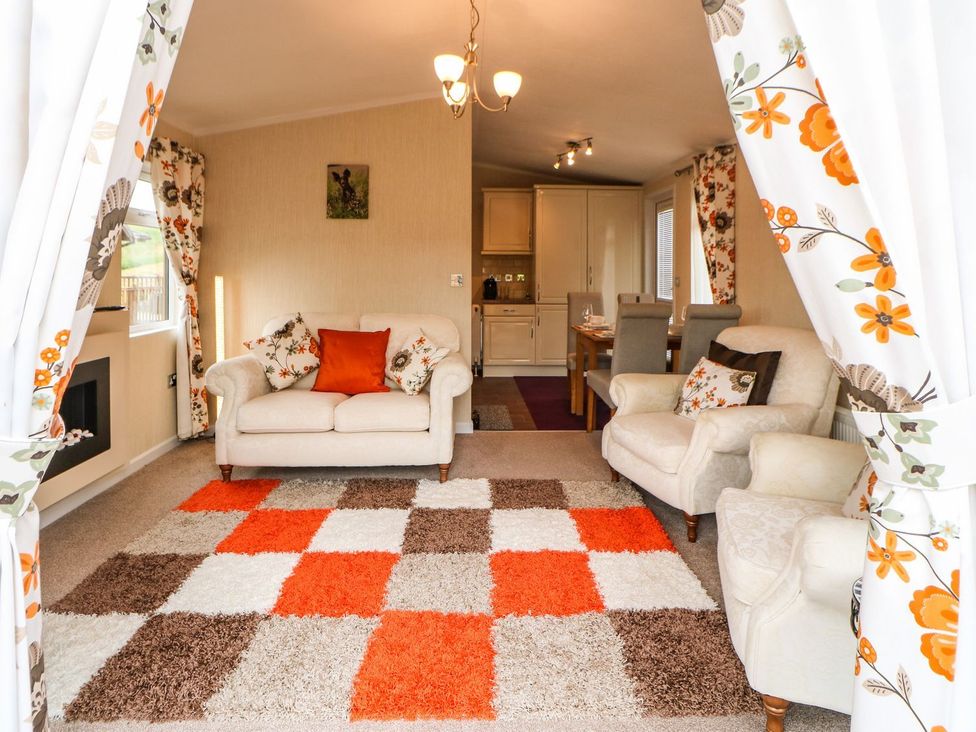 A living room with a sofa and rug at 10 Poppy Lodge in Richmond