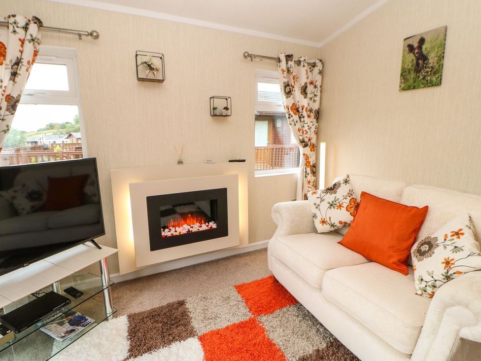 A living room with a television and sofa at 10 Poppy Lodge in Richmond