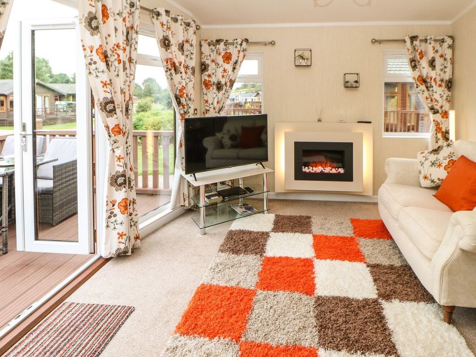 A living room with a television and fireplace at 10 Poppy Lodge in Richmond
