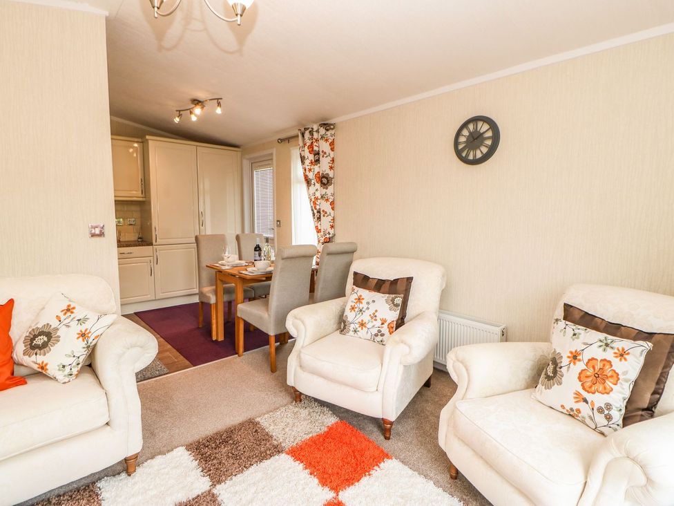 A living room with seating area and dining table at 10 Poppy Lodge in Richmond