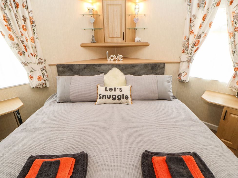 A bedroom with a bed and decorative items at 10 Poppy Lodge in Richmond