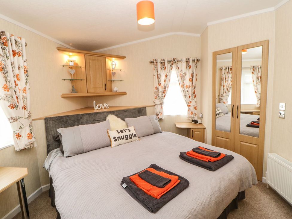 A bedroom with a bed and shelves at 10 Poppy Lodge in Richmond