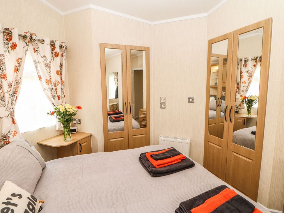 A bedroom with a bed and wardrobe at 10 Poppy Lodge in Richmond