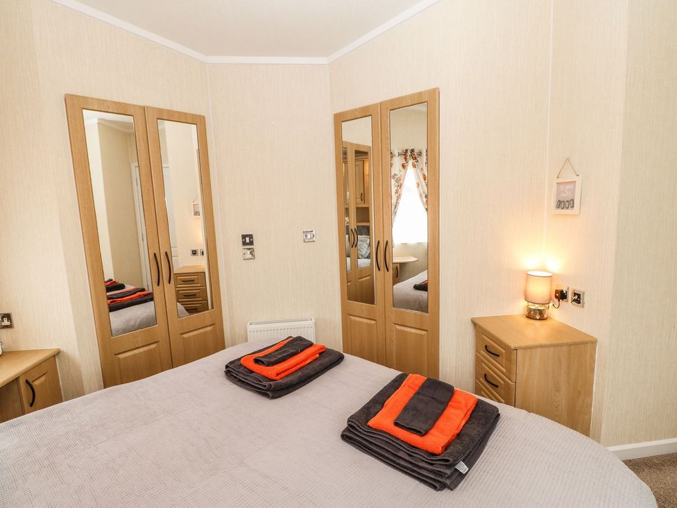 A bedroom with a bed and towels on top at 10 Poppy Lodge in Richmond