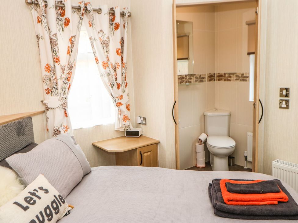 A bedroom with a bed and an adjacent bathroom at 10 Poppy Lodge Richmond