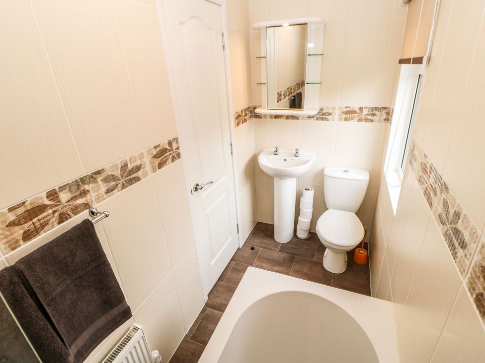 A bathroom with a bathtub, washbasin, and toilet at 10 Poppy Lodge, Richmond