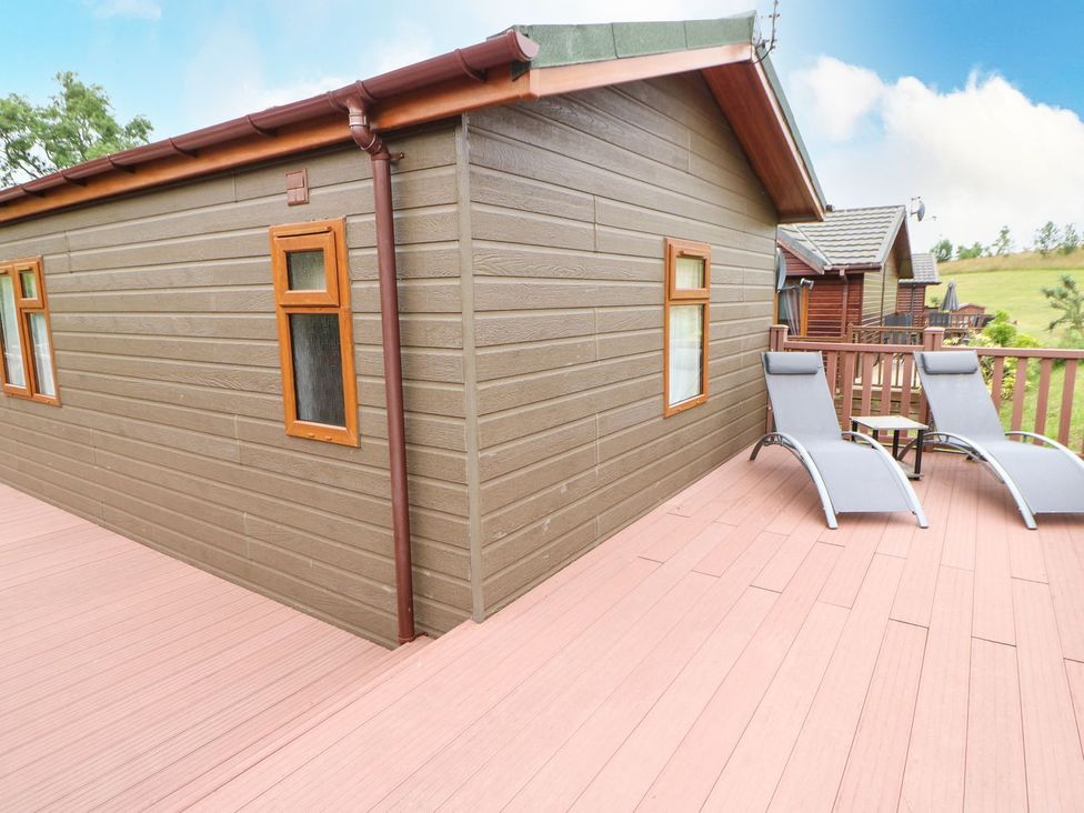An outdoor area with loungers and a wooden structure at 10 Poppy Lodge in Richmond