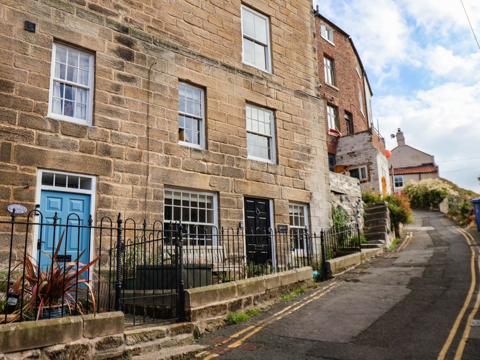 A stone building with blue and black doors and a pathway at bellebeck