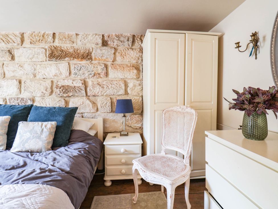 A bedroom with a bed, wardrobe, and side table at bellebeck