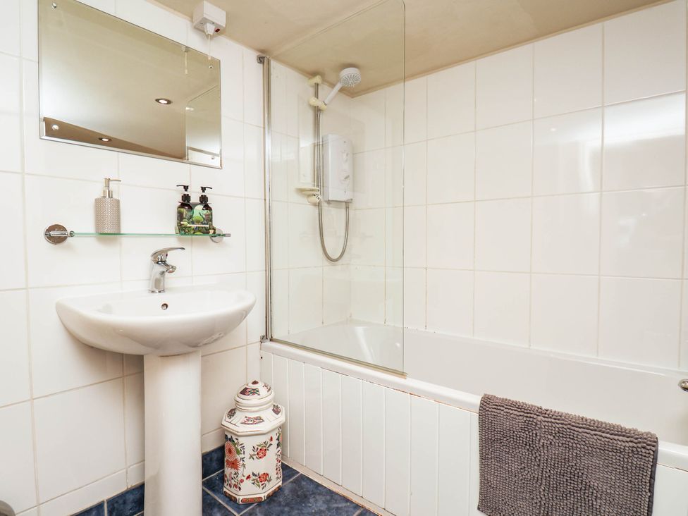 A bathroom with a sink, bath tub, shower, and mirror at bellebeck
