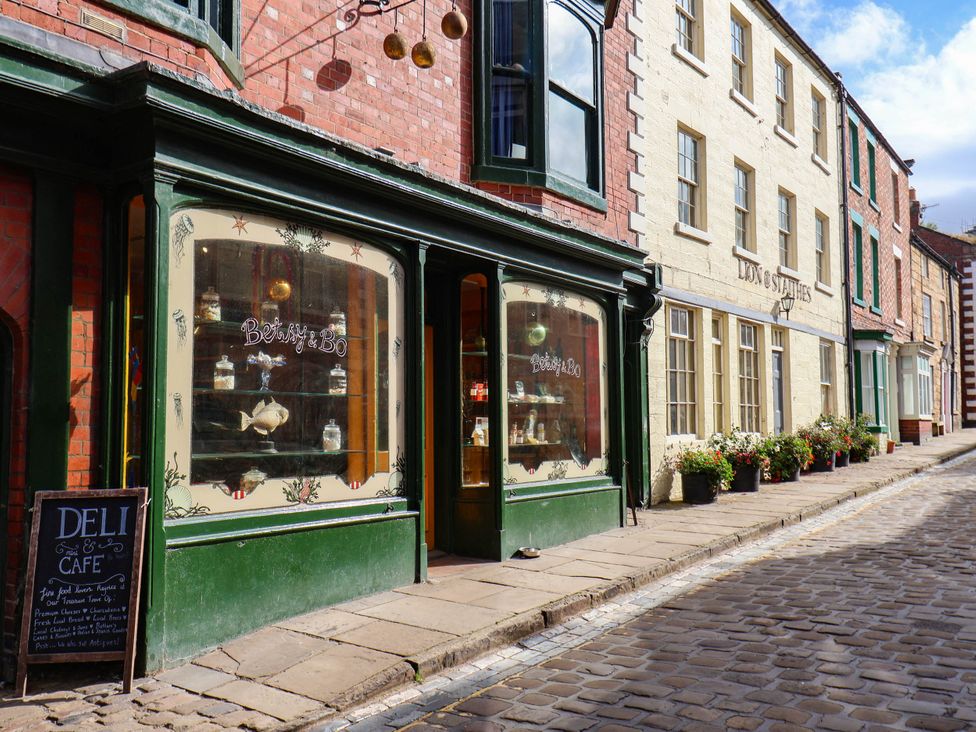 A shopfront with a sign at Betsy & Bo in an outdoor pedestrian street