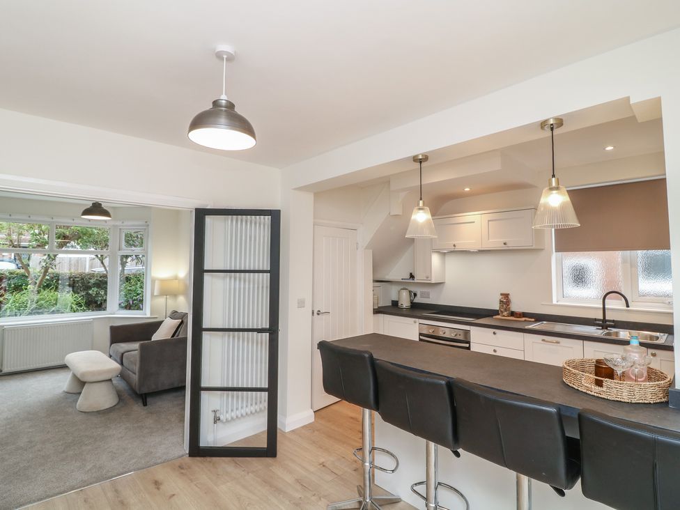 A kitchen with bar stools and a sofa at No.40 Rufford Road in Ruddington