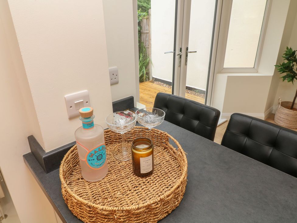 A kitchen with a bottle, glasses, and a candle on a basket at No.40 Rufford Road in Ruddington