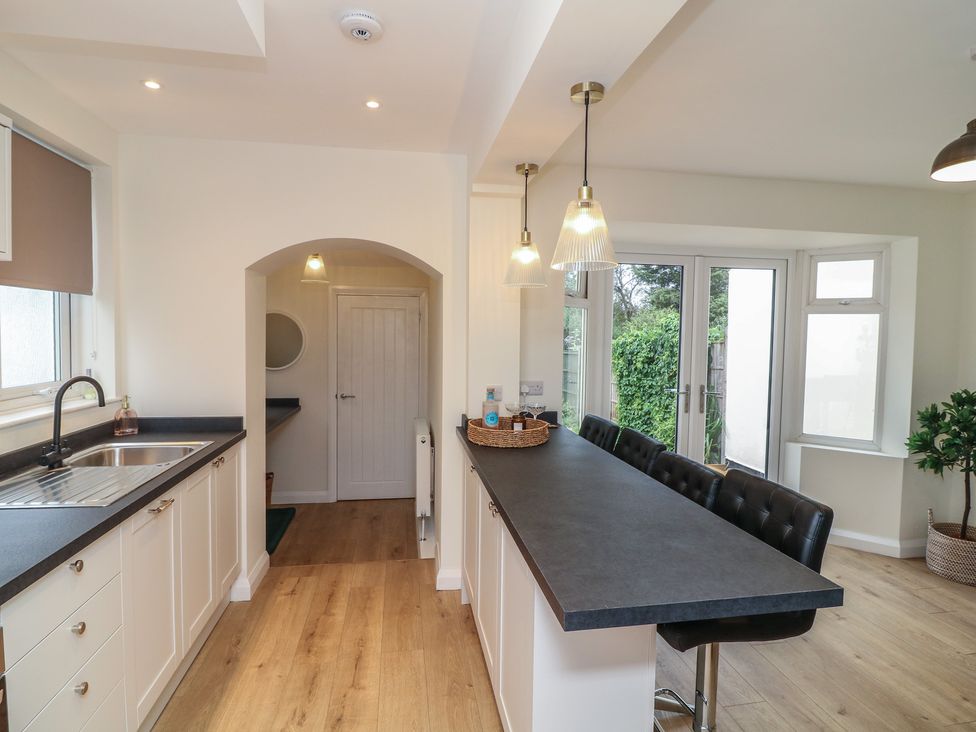 A kitchen with a sink and bar seating at No.40 Rufford Road Ruddington