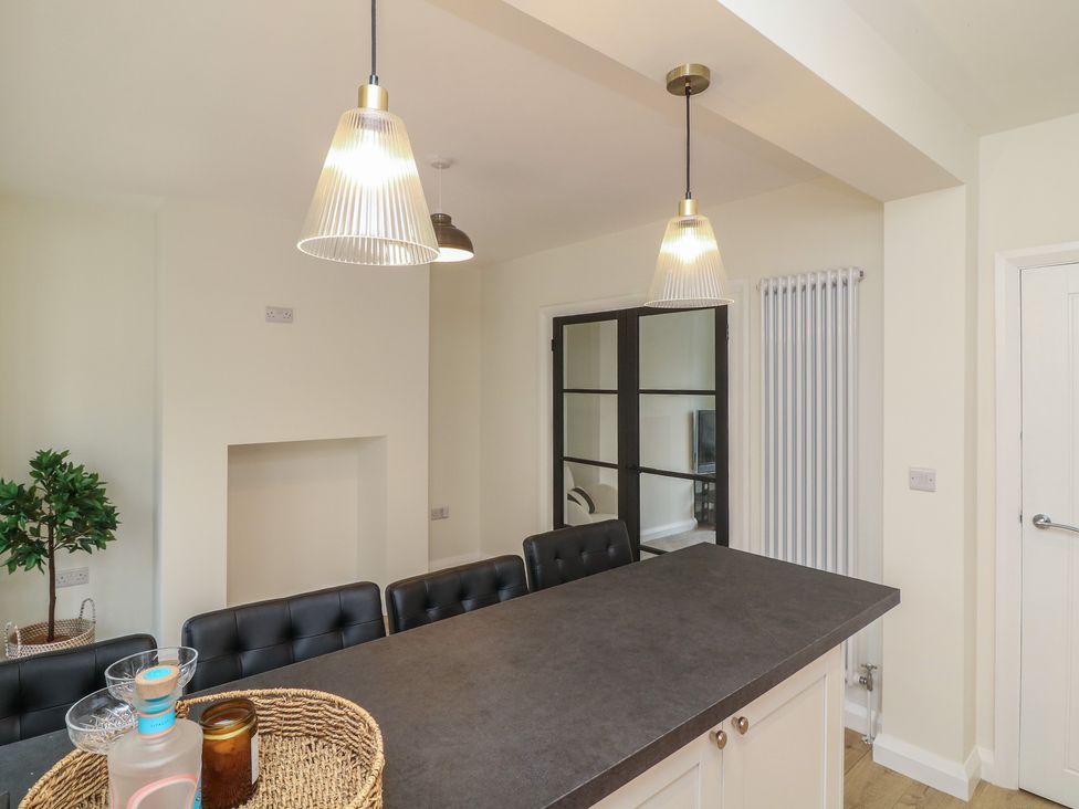 A kitchen with bar stools and pendant lights at No.40 Rufford Road in Ruddington