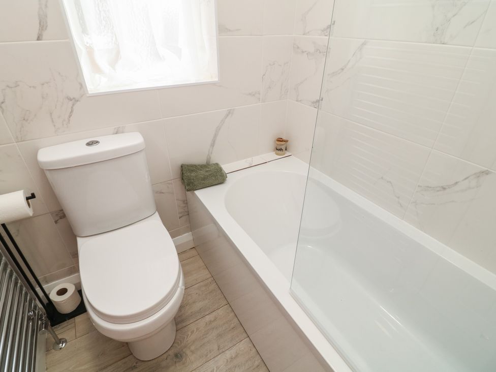 A bathroom with a toilet and bathtub at No.40 Rufford Road Ruddington