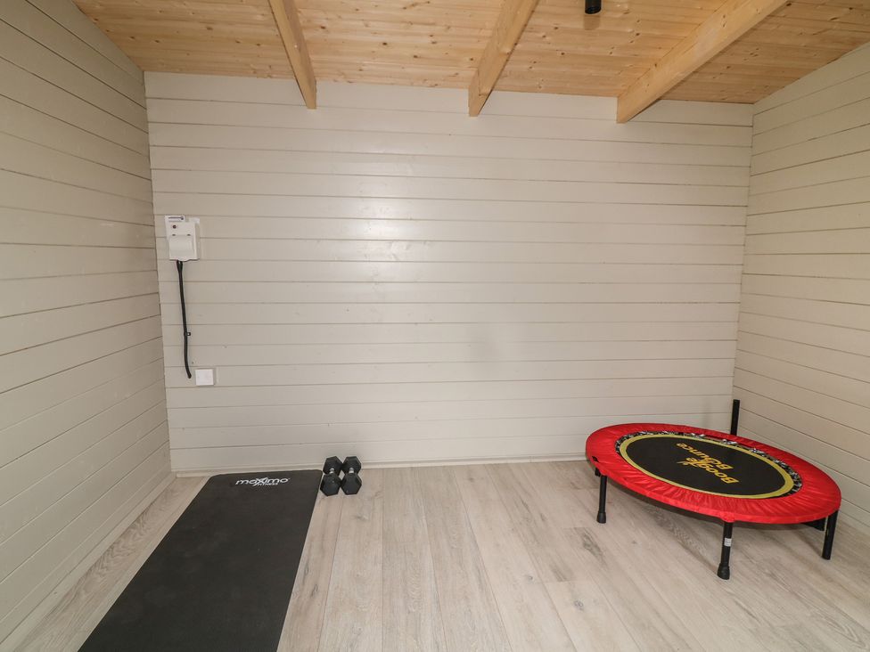 A gym with a trampoline, exercise mat, and dumbbells at No.40 Rufford Road, Ruddington