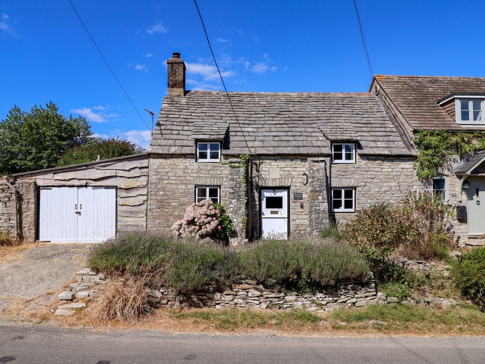 A house with a garage and garden at Farthing Cottage in Corfe Castle
