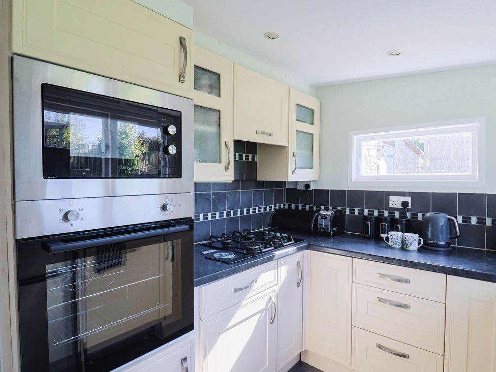 A kitchen with a gas stove and oven at Farthing Cottage in Corfe Castle