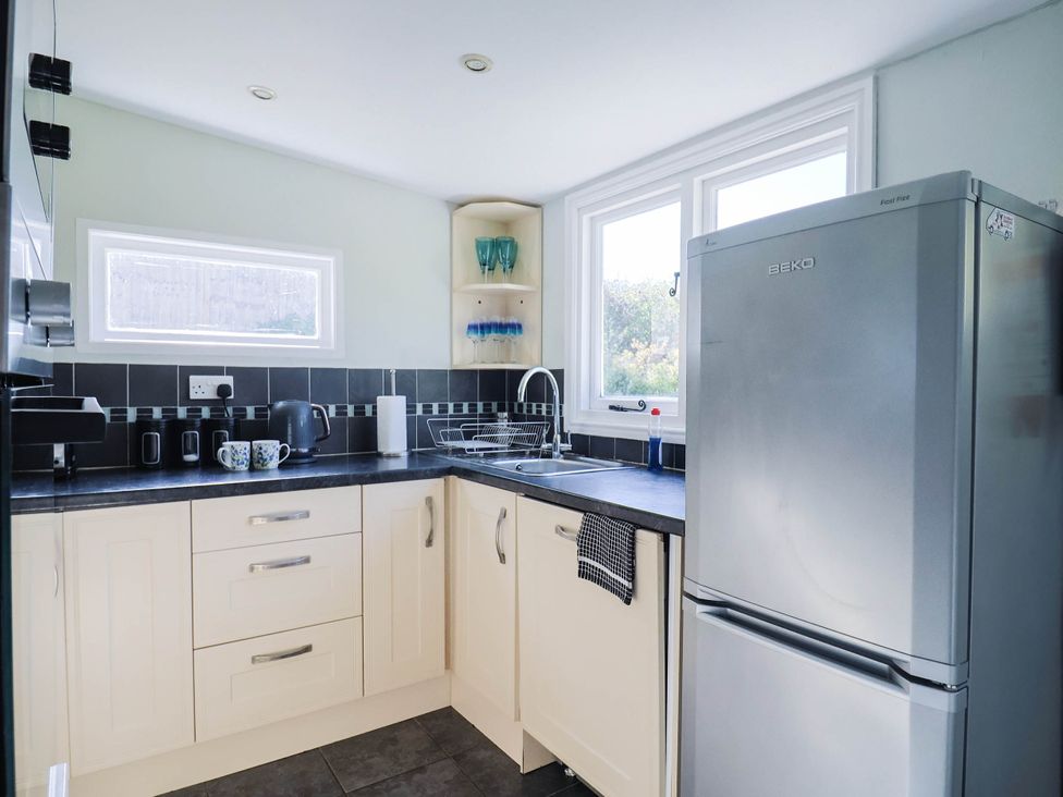 A kitchen with a refrigerator and sink at Farthing Cottage in Corfe Castle