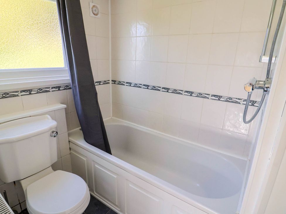 A bathroom with a bathtub and toilet at Farthing Cottage in Corfe Castle