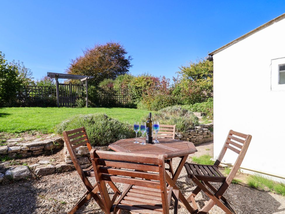 A garden with a table and chairs at Farthing Cottage in Corfe Castle