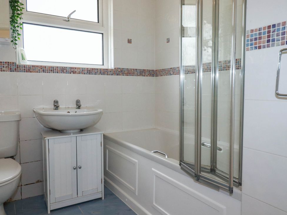 A bathroom with a sink, toilet, shower, and bathtub at Cloudbreak in Wadebridge