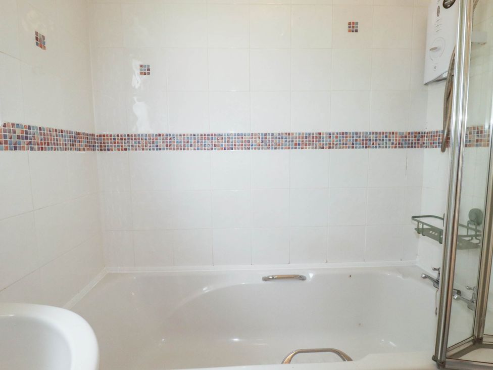A bathroom with a bathtub and shower at Cloudbreak in Wadebridge