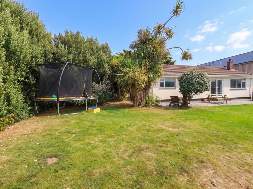 A garden with a trampoline and seating area at Cloudbreak in Wadebridge
