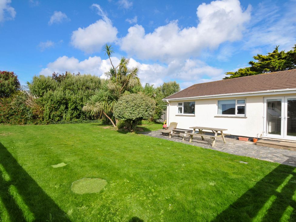 A garden with a house and seating area at Cloudbreak in Polzeath