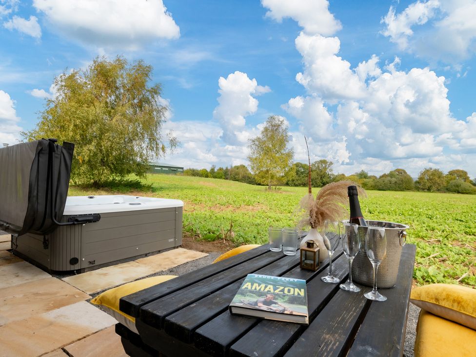 An outdoor area with a hot tub and table at Hambledon Hill Cottage Blandford Forum