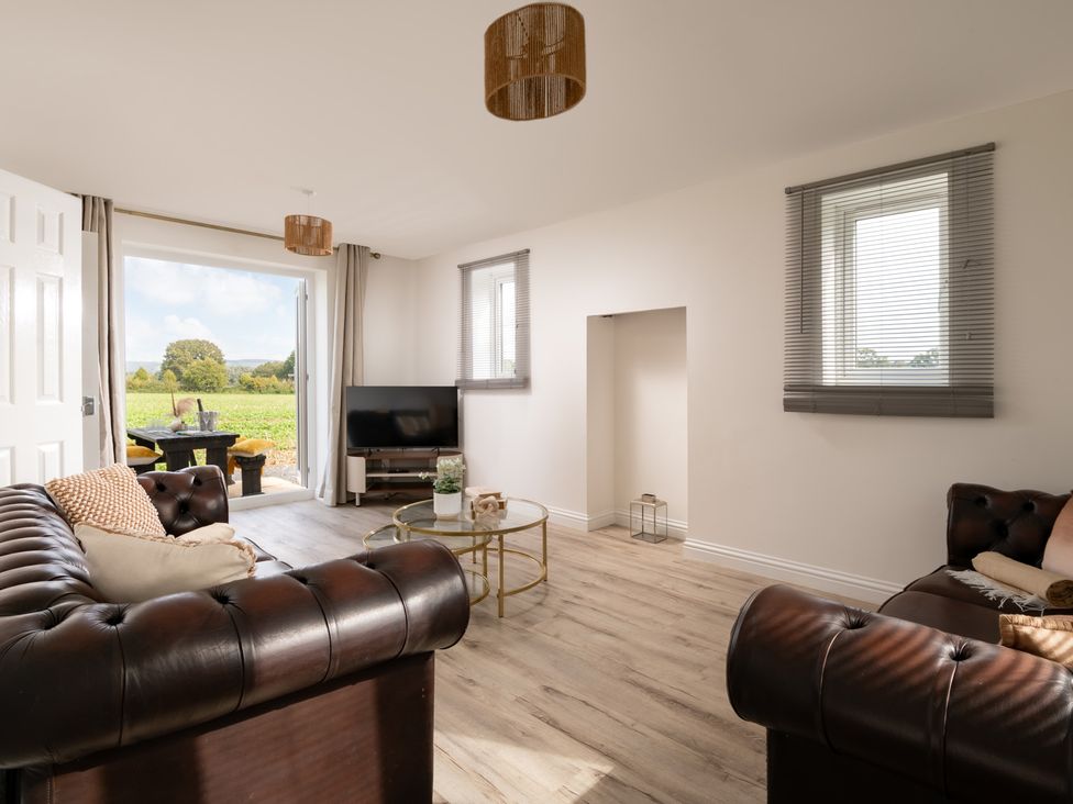 A living room with a sofa and television at Hambledon Hill Cottage in Blandford Forum