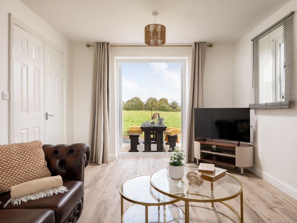 A living room with a sofa and television at Hambledon Hill Cottage in Blandford Forum