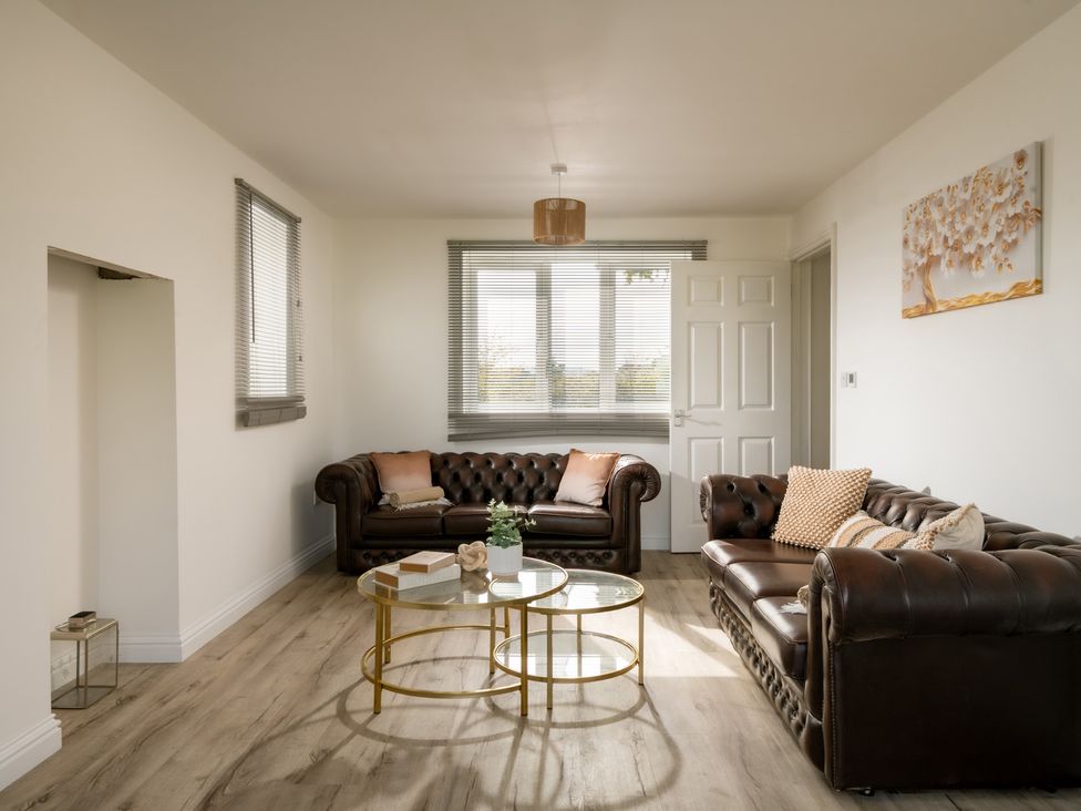 A living room with sofas and a coffee table at Hambledon Hill Cottage in Blandford Forum
