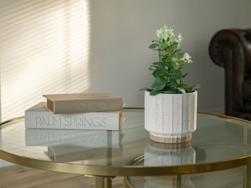 A coffee table with books and a potted plant at Hambledon Hill Cottage in Blandford Forum