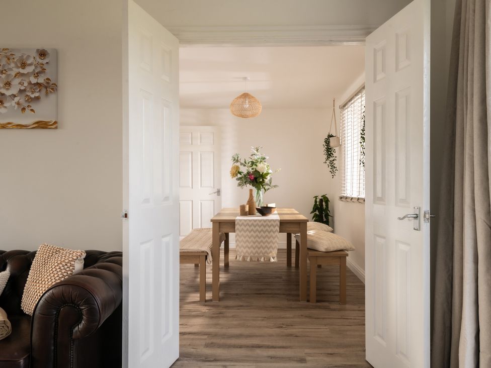 A dining room with a table and benches at Hambledon Hill Cottage in Blandford Forum