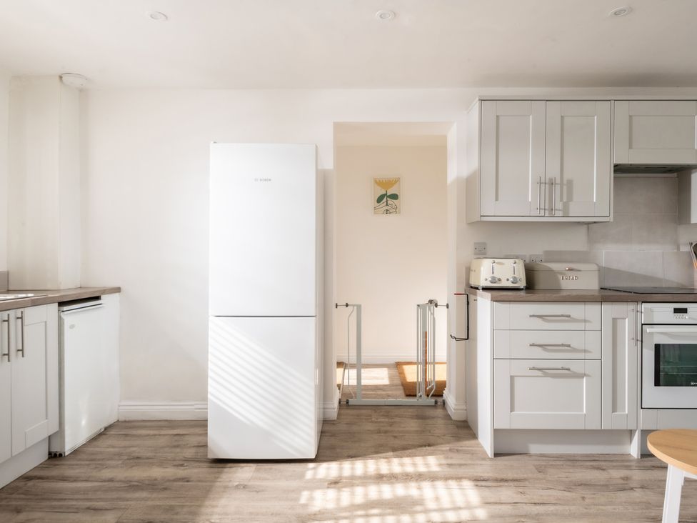 A kitchen with a refrigerator and countertop at Hambledon Hill Cottage in Blandford Forum
