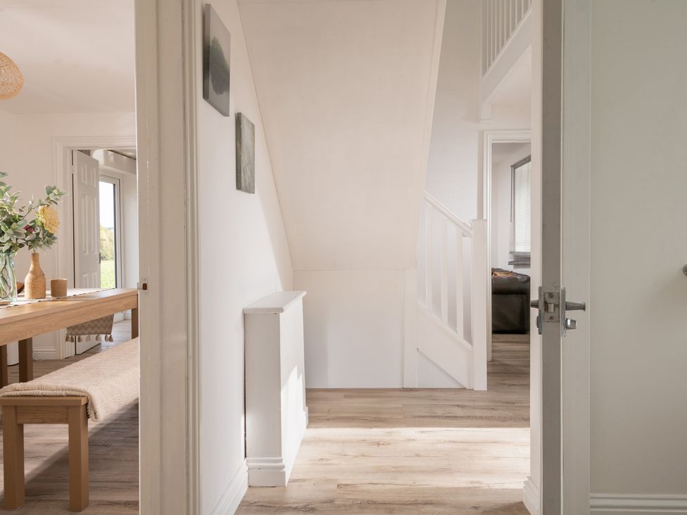A dining room with a table and bench at Hambledon Hill Cottage in Blandford Forum